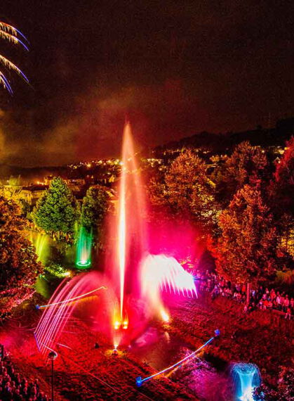 Lichterfest in Bad Salzschirf Farbige Wasserspiele mit Fontaine in allen Farben. Außen herum sind Bäume